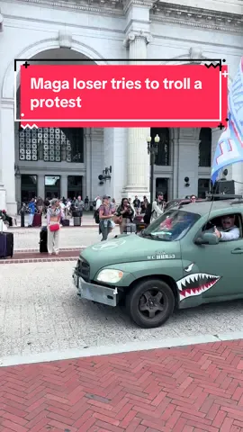 A green car with a “trump for king” flag drives in front of a protest at union station. Veterans and others have been protesting Trump’s take over of DC. 
