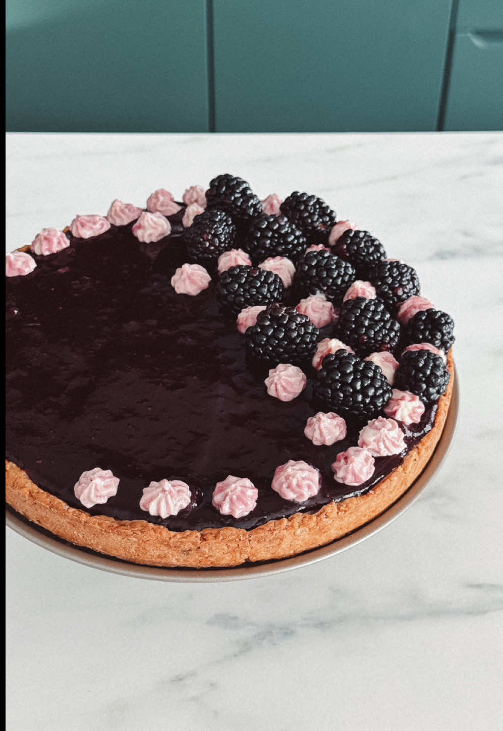 tartă cu cremă de vanilie și coulis de fructe de pădure  Crustă: - 170g făină, - 40g zahăr, - puțină sare, - 80g unt tăiat cubulețe, - 1 gălbenuș, - esență de vanilie, - 2 linguri apă rece, - câteva migdale tăiate. Cremă de vanilie: - 3 gălbenușuri, - 250 ml lapte, - 50g zahăr, - 20g amidon, - esență de vanilie,  - 30g unt, - zahăr vanilat. Coulis de fructe de pădure: - 200g fructe de pădure, - 50g zahăr, - 15g amidon. - fructe pentru decor  Începem cu aluatul pentru crustă. Amestecăm faina cu zahărul, migdalele, untul tăiat cubulețe, gălbenușul, apa și esența de vanilie. Amestecăm bine ingredientele până când obținem un aluat elastic. Îl modelăm sub formă de bilă și îl dăm la frigider pentru 30 de minute. Între timp încălzim cuptorul la 180 de grade.  După cele 30 de minute, întindem aluatul într-o foaie rotundă cu o grosime de 5mm.  Punem aluatul într-o tavă tapetată cu hârtie de copt și îl presăm astfel încât să ia forma tăvii. Tăiem marginile așa cum puteți vedea în videoclip și îl înțepăm cu o furculiță. Peste aluat punem hârtie de copt, iar peste aceasta orez sau fasole pentru a-și păstra forma în timpul coacerii. Punem la cuptor pentru 20 de minute. Scoatem hârtia cu orezul și mai lăsăm în cuptor pentru încă 10 minute.  Cat timp se răcește aluatul, facem cremă de vanilie. Pentru aceasta punem într-o cratiță gălbenușurile cu zahărul și le amestecăm. Separat dizolvăm amidonul în lapte și îl adăugăm și pe acesta. Pornim focul și amestecăm continuu până se îngroașă. Oprim focul și adăugăm untul cu zahărul vanilat și esență de vanilie. Le încorporăm și pe acestea, apoi punem crema caldă peste crusta care s-a răcit.  Facem și coulis-ul din fructe de pădure, eu am folosit fructe congelate. Le punem într-o cratiță împreună cu zahărul și le gătim pentru 10 minute. Când sunt gata strecurăm semințele, iar crema obținută o punem din nou pe foc cu amidonul dizolvat în puțină apă. Mai gătim pentru 3 minute, apoi punem coulis-ul peste tartă.  Lăsăm tarta la racit pentru câteva ore și o decorăm cu fructe proaspete. 🥰 #retete #reteteusoare #desert #yummy #recipesoftiktok 