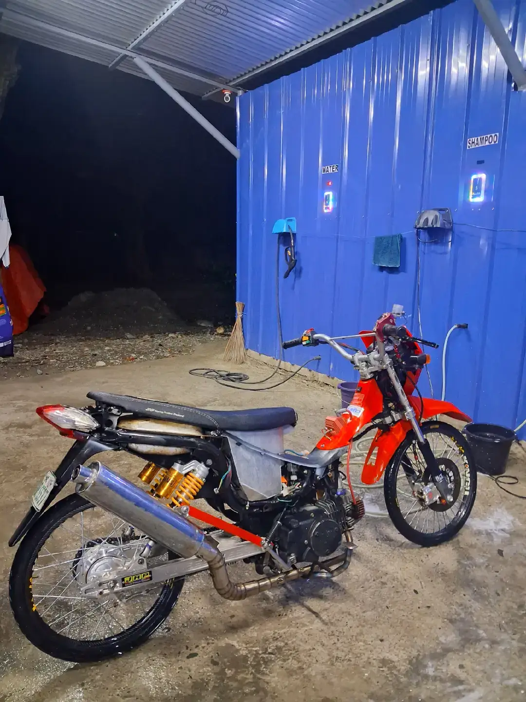 @V I 0 L A:📍A realistic photo of a detailed 1/7 scale model kit of a black and red Yamaha Aerox scooter same as the picture attached and placed on a wooden desk. Behind it is the model kit box showing the same scooter image with the brand 
