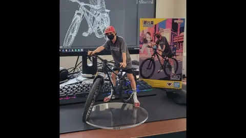 image to video #ai prompt,Two hands gently pick up the figure in the frame and rotate it slightly for inspection. The model on the computer screen and the model printed on the packaging box remain stationary, while all other background elements stay unchanged. #aiviraltrend