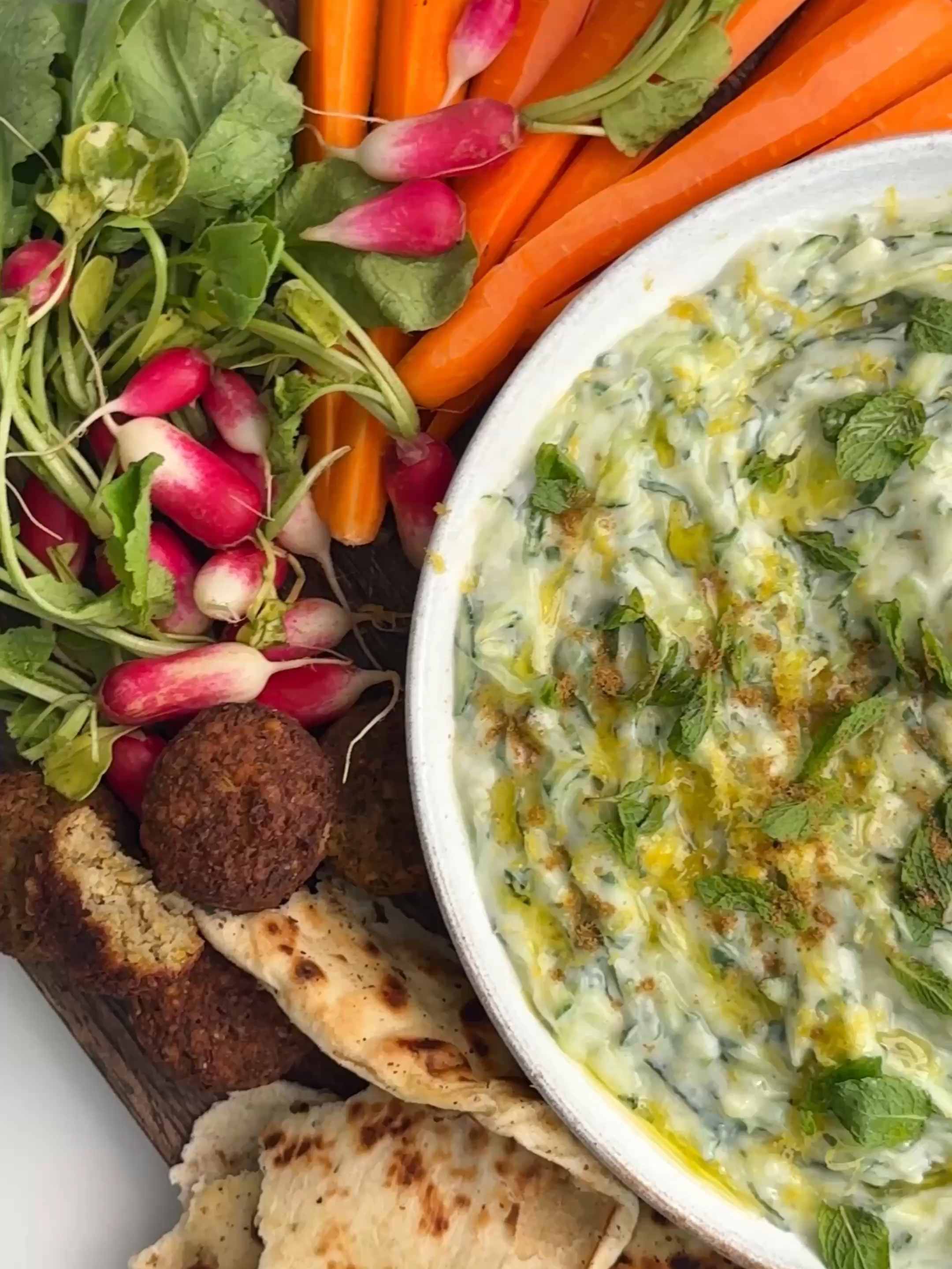 Cool, creamy & so refreshing 💚   Crisp cucumber, a squeeze of lemon, plenty of garlic and a fresh lift from mint - all stirred through creamy yoghurt. Perfect for dunking crunchy veggies, scooping up with warm flatbreads or adding to just about anything for that zesty, herby freshness ✨ Here’s what you’ll need 💕 0.5 teaspoon fine sea salt  200 g cucumbers (about 1/2 a cucumber), unpeeled & grated  2 cloves garlic, grated  0.5 lemon, zested & juiced  100g dairy-free yoghurt 1 tablespoon mint How to make it 💕 1. Sprinkle the salt onto the cucumber and squeeze between your hands to release some of the water. 2. Put the squeezed cucumber and the remainder of the dip ingredients into a bowl and stir together until combined. Season with a good crack of black pepper to taste and top with a few mint leaves to serve. If you’re a member, for this recipe, search ‘Tzatziki Dip’ in our app or at deliciouslyella.com 🌱
