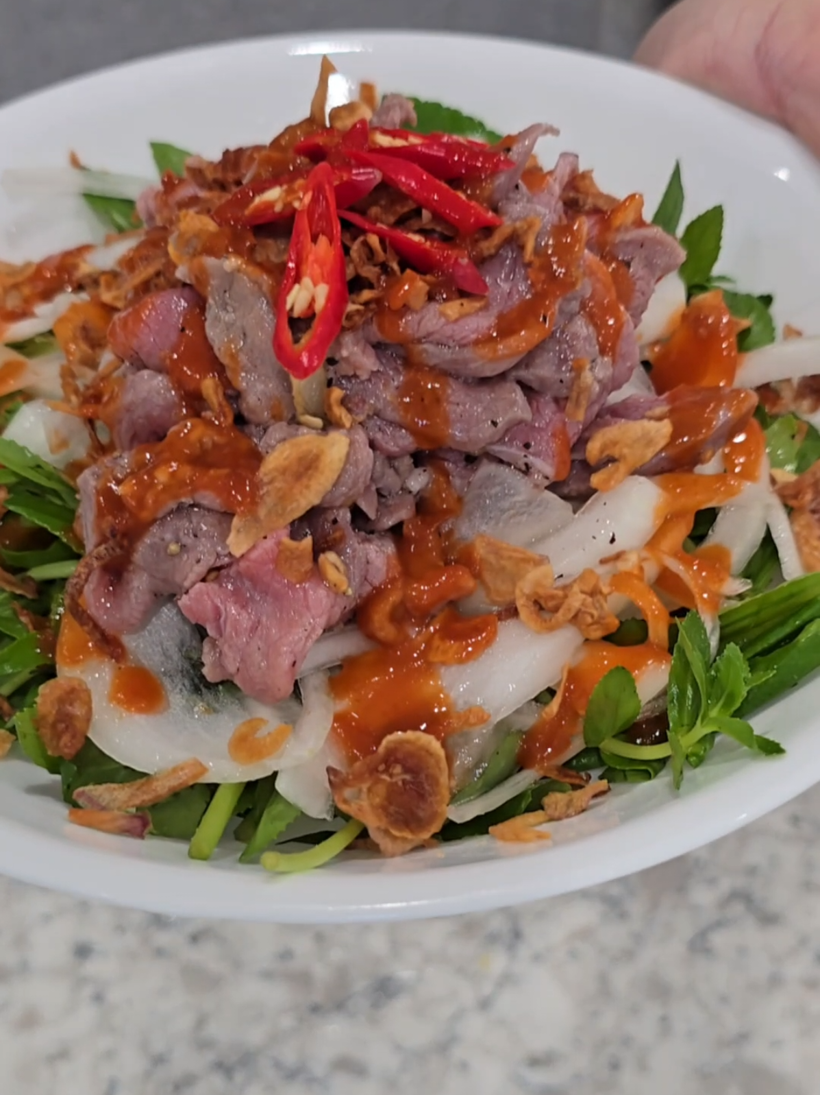 Rare beef salad (Bò Tái Chanh) #rarebeefsalad #asianrecipe #beef #rare  Recipe: Beef: (thinly sliced, salt, black pepper, sugar, lime and fried garlic.  Pickled onions: soak in ice water then 2 part sugar to 3 part vinegar. Assemble: Rice paddy herb, culantro, chili, fried shallots and Sriracha (optional). As always, adjust ingredients to your liking! 