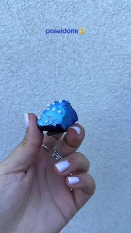 Poseidone🔱  Dietro questo scatto c’è un piccolo sassolino realizzato per richiamare i toni del mare e della sua lucentezza🌊 È stato creato un effetto di sfumatura che richiamasse il movimento delle onde, dal blu profondo al celeste più chiaro, per poi applicare con cura perline che, al sole, brillano come gemme marine, quasi a voler riflettere la luce che si specchia sulla superficie dell’acqua.📿 #perte 