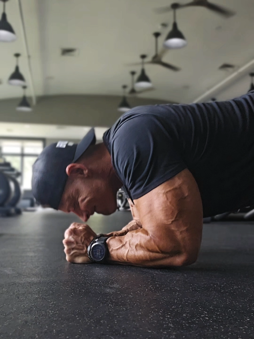 The Hardest Triceps Move You’ve Never Tried 💪 Bodyweight Skull Crushers on Fists.  This exercise is a finisher movement for me.   Setup: 1. Get into a push-up–style position, but bring your fists together directly under your forehead/mid face. 2. Balance on the back edge of your fists (near the pinky side), keeping them pressed firmly into the ground and together.  Movement: 1. Bend only at the elbows, lowering your head down toward your fists as if you were bringing your nose to your knuckles. 2. Keep your upper arms locked in place and elbows pointed forward. 3. Press through your fists to extend your arms and return to the starting position, squeezing the triceps hard at the top. Key Points: Fists stay tight together throughout the movement. Don’t flare your elbows keep them tucked to maximize triceps activation. To make it easier, drop your knees to the floor. To make it harder, elevate your feet or slow down the tempo. #tricepsworkout #tricepsday #bodyweightexercises #armday #bodybuilding 