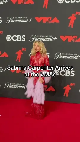 It’s Sabrina’s world and we’re just living in it. #SabrinaCarpenter wore a red lacey dress at tonight’s #VMAs, with a pink stole included. Could this be a hint at her performance tonight? Head to the link in our bio to see more starry arrivals from the award ceremony.  