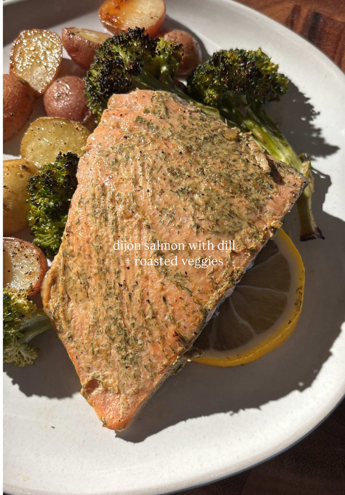 EASY MONDAY DINNER IDEA: Dijon Salmon with Dill and Roasted Veggies on one sheet pan, ready in 30 minutes!  INGREDIENTS • 1 1/2 cups baby potatoes, halved • 1 head broccoli florets • 1 TBSP oil • 1 TSP salt • 1 TSP pepper • 1 TSP garlic powder • 1 TSP onion powder • 1lb salmon (cut into 3-4 fillets to cook more evenly/faster) • 2-3 TBSP Dijon mustard • 2 TBSP dried dill  1. Preheat oven to 425F. 2. Chop veggies: halve potatoes, and cut a head of broccoli into florets 3. Toss veggies with oil and season with salt, pepper, garlic and onion powder 4. Roast for 15 minutes on a sheet pan. 5. While veggies roast, dice one lemon into thin slices and brush Dijon to each salmon fillet,  generously with Dijon and dried dill. 6. Remove veggie sheet pan and nestle lemon slices into the veggies. Lay salmon over lemon and roast for 12 minutes.  7. Remove from oven, let cool. Serve and enjoy! #sheetpandinner #salmondinner #mondaymeals #glutenfreerecipe 