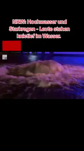 NRW: Hochwasser und Starkregen - Leute stehen knietief im Wasser.