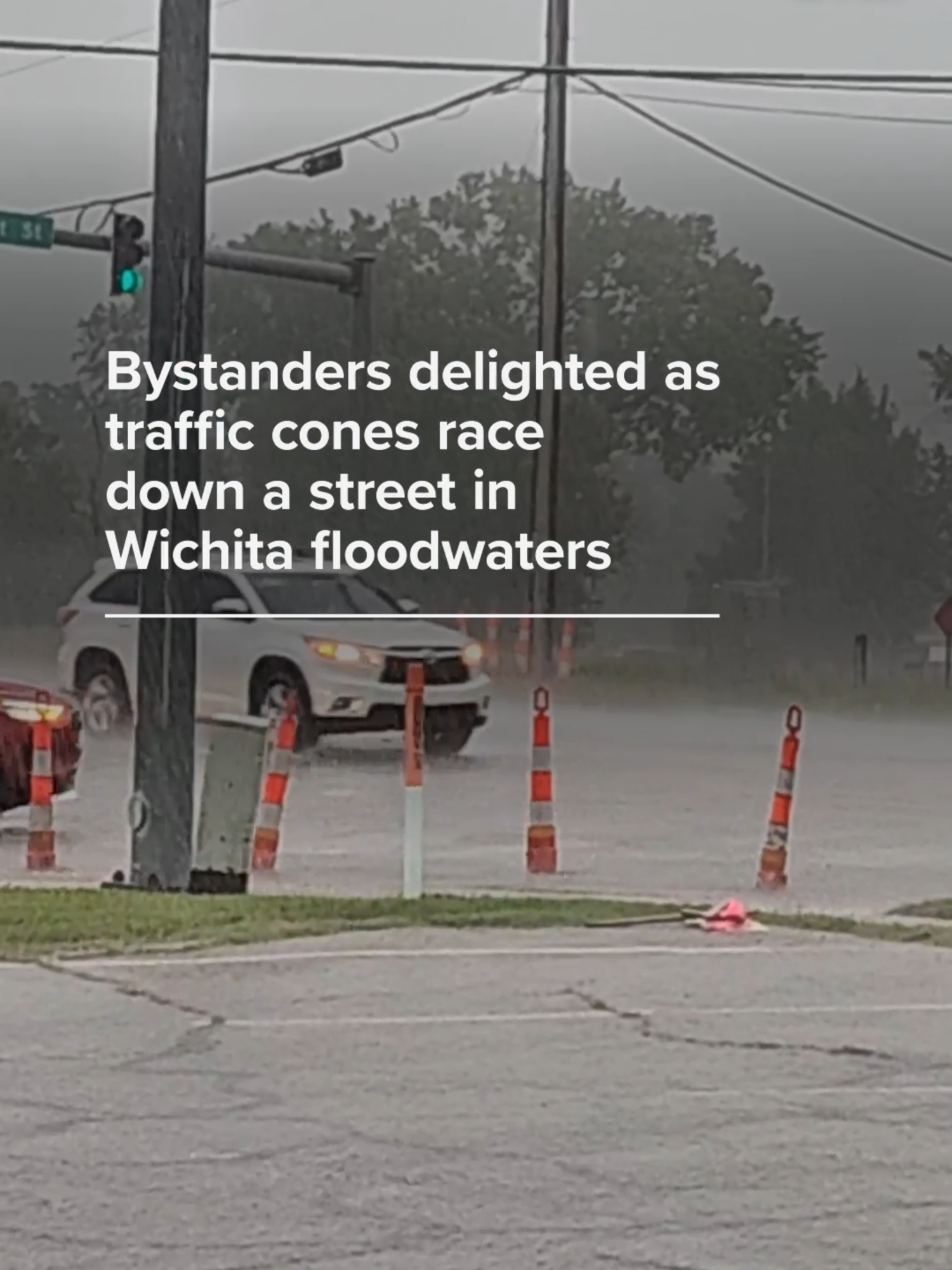 Bystanders laughed with delight at a group of traffic cones whizzing down a Wichita street single-file as floodwaters carried them away. 
