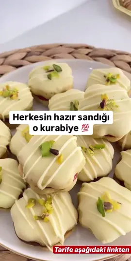 Antep Fıstıklı Beyaz Çikolatalı Kurabiye Tarifi | Pastane Usulü Çay saatleri ve misafir sofraları için enfes kurabiye! Antep fıstıklı ve beyaz çikolatalı kurabiye tarifiyle hem şık hem de lezzetli atıştırmalıklar yapabilirsiniz. Malzemeler 125 g tereyağı veya margarin 1 çay bardağı nişasta (yarısı mısır, yarısı buğday) 1 çay bardağı sıvı yağ 1,5 çay bardağı pudra şekeri 1 adet yumurta 1 çay kaşığı kabartma tozu 3 su bardağı un (kontrollü ekleyin) 2 yemek kaşığı toz Antep fıstığı Üzeri için: 1 paket beyaz çikolata File Antep fıstığı Arası için: Eritilmiş sütlü çikolata, reçel veya çokokrem (isteğe göre) Hazırlanışı Uygun bir kaba tüm malzemeleri alın, unu azar azar ilave edin. (Benim yumurta büyük olduğu için 3 bardak + 2 yemek kaşığı un aldı.) Hamur toparlanınca fıstık tozunu ekleyin. Ele yapışmayan yumuşak bir hamur elde edin. Hamuru buzdolabında 20 dk bekletin. Hamuru birkaç parçaya bölüp iki yağlı kağıt arasında açın. Kurabiye kalıbıyla kesin. Kontrollü şekilde pişirin ve soğumaya bırakın. Beyaz çikolatayı 2 yemek kaşığı süt ile benmari usulü eritin. Kurabiyelerin arasına çikolata, reçel ya da çokokrem sürüp birleştirin. Üst kısımlarını erimiş beyaz çikolataya batırın, şerit halinde çikolata gezdirin. File Antep fıstığı serpip buzdolabında dinlendirin. #ftypシ #tarifler #yemektarifleri #tarif #keşfet    