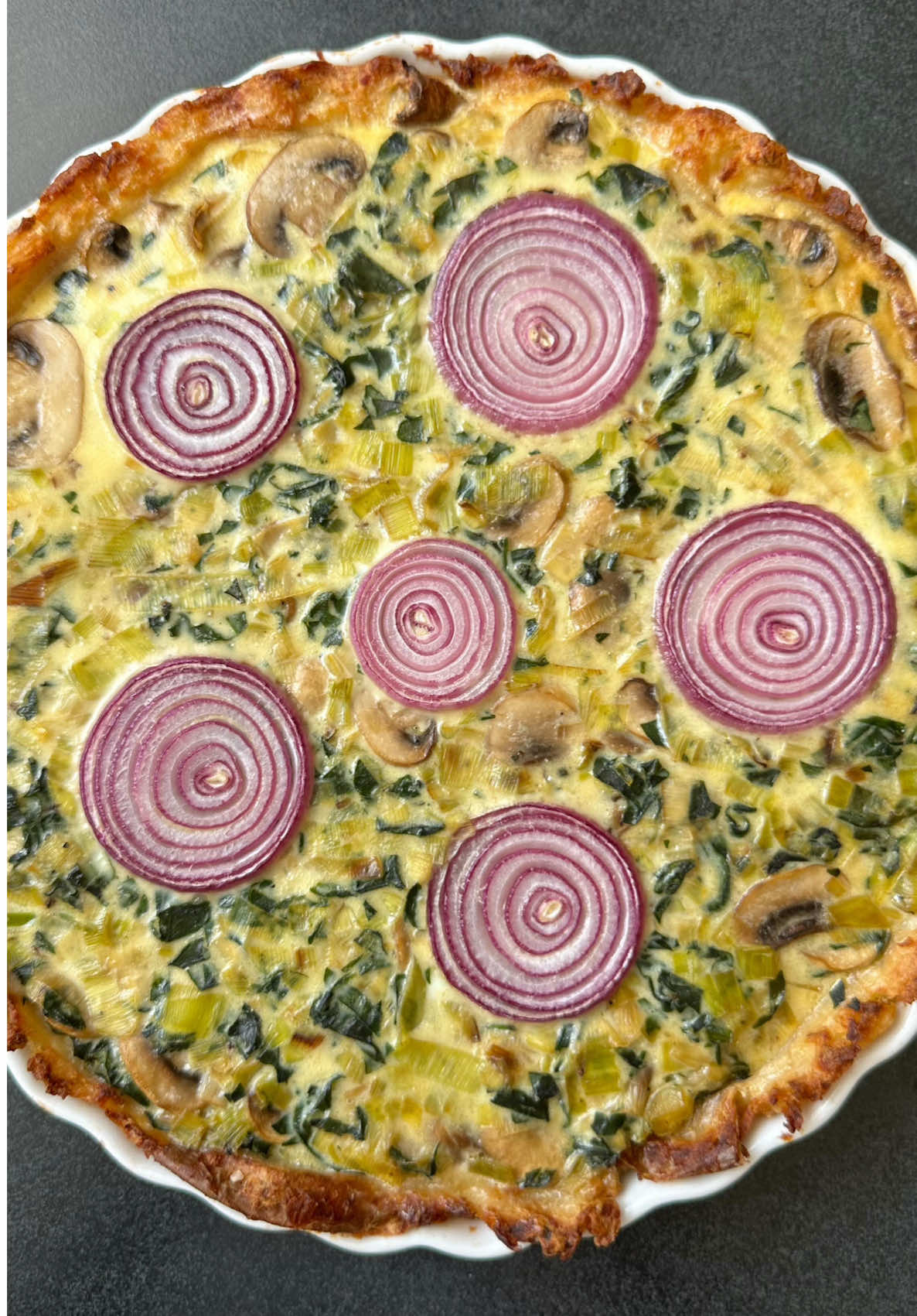 Leek, Mushroom and Spinach Quiche by @rontav123 🥔🌿  Get the recipe below / at the link in bio and keep tagging #feedfeed for a chance to be featured.  INGREDIENTS  For the base:  5 medium potatoes  Olive oil  Salt and pepper to taste  For the filling:  3 medium leeks, sliced into rounds  2 packages of mushrooms - sliced  300 grams of fresh spinach leaves, washed and cut  2 tablespoons of olive oil for frying  Red onion, sliced into rounds  4 eggs  250 ml of 16% fat heavy cream  Half a cup of grated Parmesan cheese (optional)  Salt and pepper to taste  RECIPE:  1. In a pot filled with water with a tablespoon of salt, cook the potatoes until tender.  2. Preheat oven to 220 degrees, roasting program. Cut each potato in half. Place the halves in an oven pan covered with baking paper greased with olive oil - cut side facing down. Bake for about 20 minutes.  3. Grease a pie dish with a little olive oil. Arrange the halved potatoes in the pie dish. Mash the potatoes with a glass. Grease the top of the potatoes with a little olive oil, season with salt and ground black pepper to taste.  4. Place in the oven to roast at 220 degrees, roasting program for about 20-30 minutes until golden-brown  5. In a hot pan with 2 tablespoons of olive oil, fry the leek, add the mushrooms and spinach. Season to taste with salt and ground black pepper.  6. Mix eggs, heavy cream, season with salt and pepper.  7. Sprinkle Parmesan cheese on top of the potato base (optional), pour the vegetables and the egg & cream mixture. Arrange the red onion slices on top.  8. Bake in an oven preheated to 170 degrees for about 40 minutes or until golden brown.  9. Remove from the oven. Wait about 10 minutes before slicing. Serve hot or lukewarm.  #quiche #brunchrecipe #breakfastideas #glutenfree 
