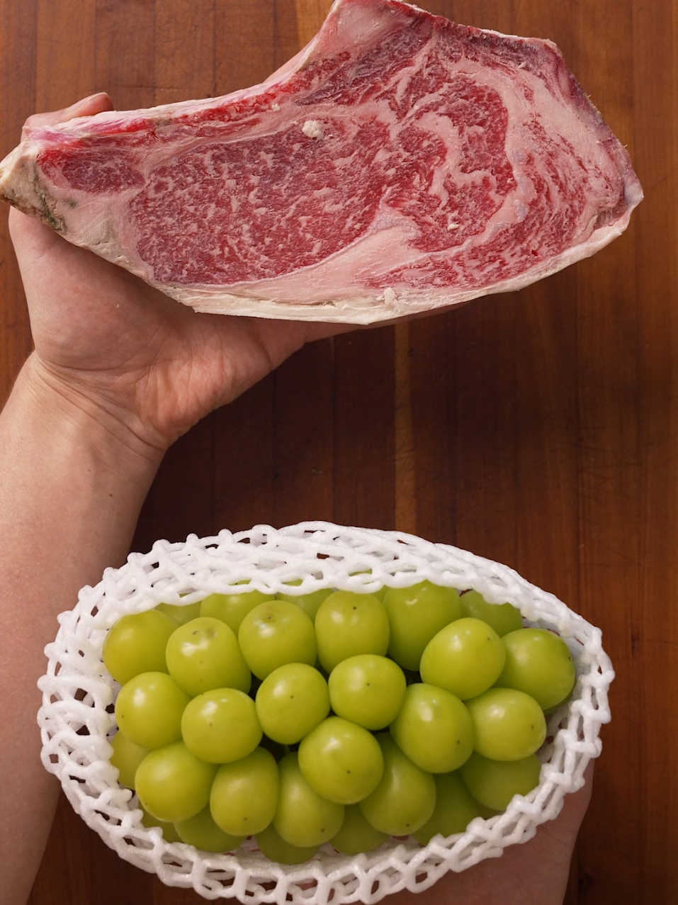 Which one of these foods do you think cost more? A dry aged ribeye steak, or some shine muscat grapes from Korea?