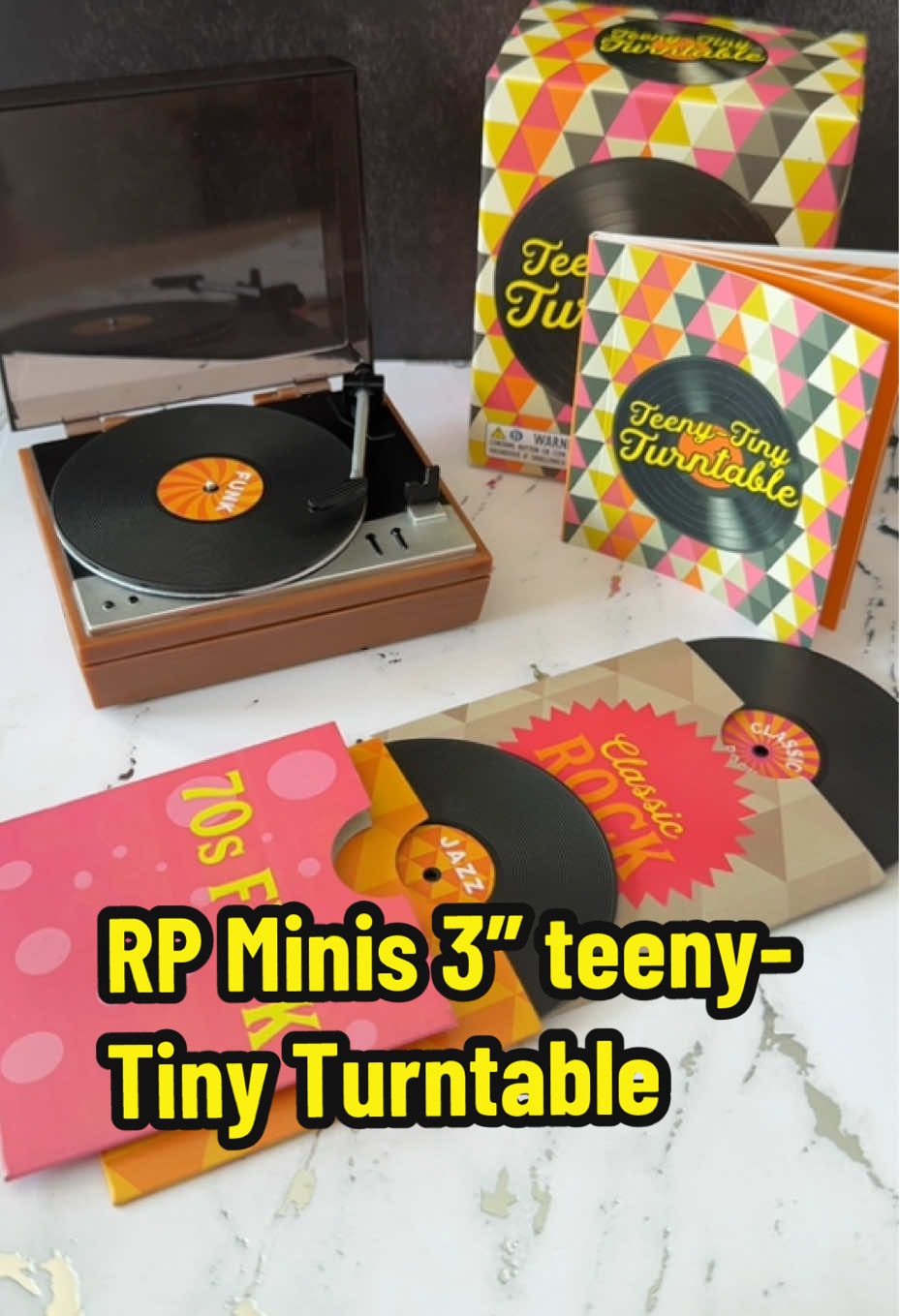 Teeny-Tiny Turntable by RP Minis [Novelty Gift] A crate diggers favorite thing—but make it tiny. 🎶 The RP Minis Teeny-Tiny Turntable actually plays mini vinyl (funk, jazz, rock) with a working tonearm + lid, sleeves, stickers, and a 32-page retro mini book. It’s the perfect nostalgia hit for Gen X, a fun desk toy for music lovers, and an easy gift for birthdays or the holidays. Tap to watch it spin and add it to your collection! #RPMinis #MiniRecordPlayer #TinyTurntable #VinylLovers #GenXNostalgia   