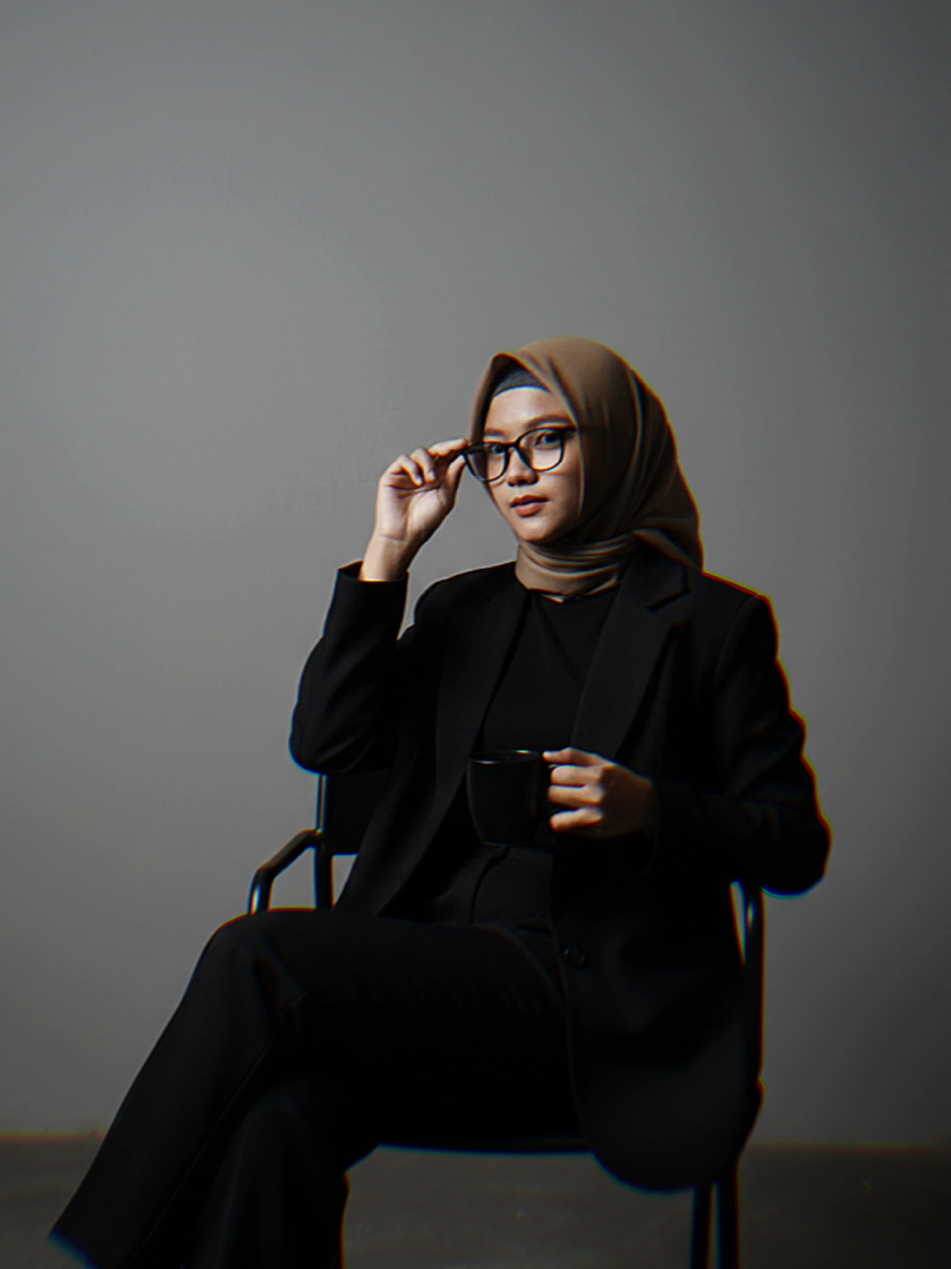 Join juga😁 Edit foto itu menjadi duduk santai di dalam ruangan polos bergaya modern dengan dinding abu-abu seperti dalam sebuah ruangan photo studio. Dia menggunakan outfit serba hitam: blazer oversize dan celana panjang hijab, tangan terlihat santai tapi elegan. Gaya gaya elegan dan edgy dengan nuansa misterius pencahayaan redup dari lampu menciptakan bayangan halus dari kursi dan badan. Tanpa merubah wajah. #gemini #geminiai #aigemini #fyp  #CapCut 