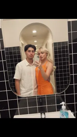 Bathroom Prompt:  Subject A: Guy in the image (DO NOT ALTER FACIAL FEATURES) Subject B: Girl in the image (DO NOT ALTER FACIAL FEATURES) The most real and human possible, create an image that looks like a selfie/portrait taken with an iPhone; this is a mirror selfie taken by Subject A using the iPhone’s back camera at arm’s length, both Subject A and Subject B looking directly at the camera through the glass while Subject A other hand wraps around Subject B’s shoulder in a tender, romantic pose, inside a restroom clad in black square tiles with white grout, a rounded-rectangular wall mirror above the sink, the sink rim and a blue pump soap bottle visible at the bottom, with an arched doorway and ceiling lights receding behind; there should be a clear subject or specific composition — just a casual, unintentional snapshot. Portrait orientation, 4:5 aspect ratio; eye-level angle with a slight leftward tilt; ~26mm equiv focal length; exposure around f/1.9, 1/160s, ISO 125 under warm indoor lighting with readable tile grout texture and faint mirror smudges; subtle hand motion from the shutter press. It has slight, natural motion blur. No color grading, no stylization, no cinematic look. The background must be fully sharp and in focus — no bokeh, no depth-of-field effect, no portrait mode. Framing: off-center, a bit crooked, part of Subject A’s face sharply captured; all images aspect ratio should be portrait 4:5. It must not look AI-generated, but rather like it was taken by a real person. . . . #sabrinacarpenter #sabrina #gemini #fyp #viral 