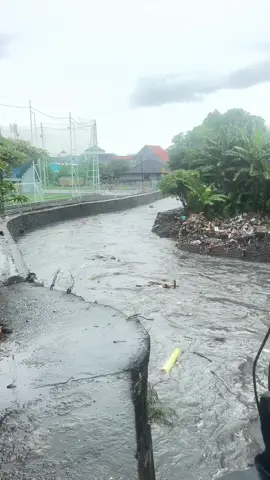 Mimih dewa ratu,  Denpasar – Hujan lebat yang mengguyur Kota Denpasar sejak pagi ini menyebabkan debit air di Tukat Mati meningkat drastis. Dari pantauan di lapangan, permukaan air terlihat membesar dan hanya sedikit lagi mencapai bagian bawah jembatan. Kondisi tersebut menimbulkan kekhawatiran warga, mengingat arus deras berpotensi meluap jika hujan deras terus berlangsung. Masyarakat diimbau untuk tetap waspada, terutama yang beraktivitas di sekitar aliran sungai dan kawasan rendah yang rawan tergenang. #denpasar #fyp #viral #bencanaalam #bali 