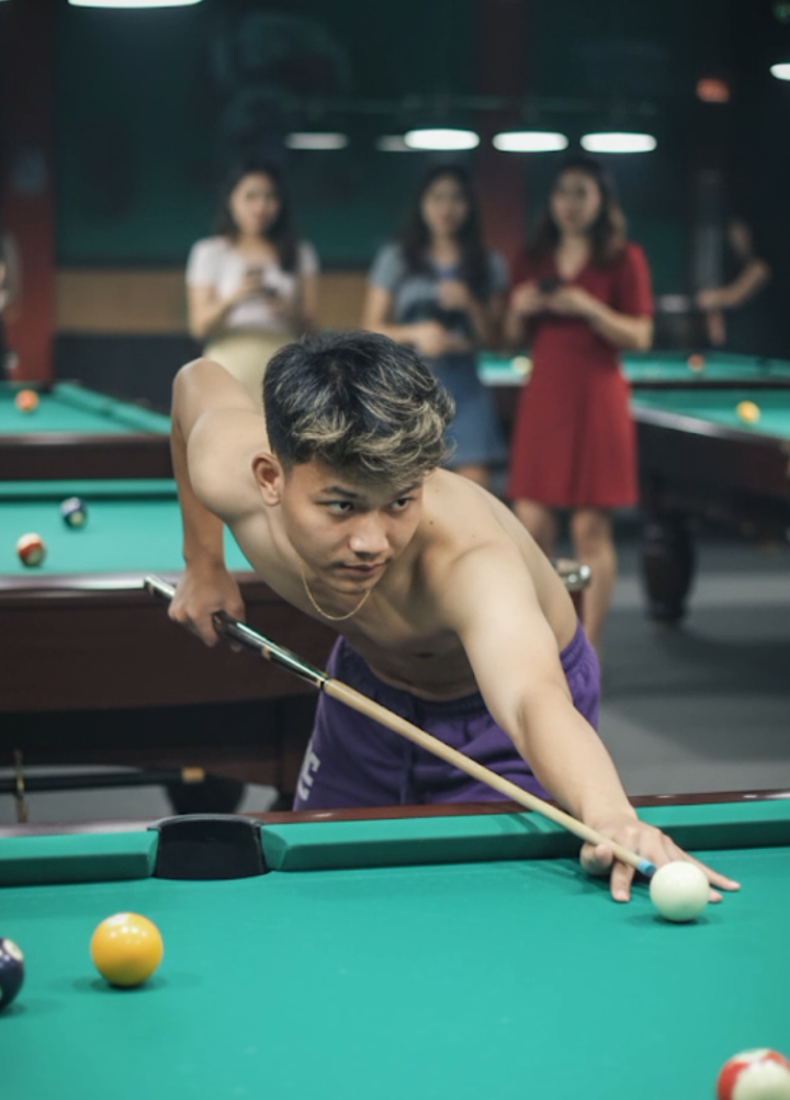 HD oge nyeaa Tpi naha pake koloyy😁 • fromt edit foto ini berdiri membungkuk dari samping sedang menyodok bola billiard di depan meja billiard dengan satu tangan memegang stik edit dengan latar belakang beberapa meja billiard dan beberapa perempuan di belakangnya #CapCut #gemini #ai #trendai #geminiai 