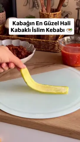 Yaz sofralarına hem hafif hem şık bir fırın yemeği arıyorsanız, bu tarif tam sizlik👌 Hem sunumu hem lezzeti süper oluyor 😍 @zeyneki 🛒 Malzemeler: 🥒 Kabaklar için: • 3-4 adet uzun kabak • 2-3 yemek kaşığı zeytinyağı • Tuz 🥩 Kıymalı harç için: • 300 gr kıyma • 2 adet soğan • 2 diş sarımsak (ezilmiş) • Birer tatlı kaşığı domates salçası ve biber salçası • Tuz, karabiber, pul biber, kimyon • 1 yemek kaşığı zeytinyağı 🧀 Üzeri için: • Dilimlenmiş kaşar peyniri • Kürdan 🍅 Domates sos için: • 3 adet rendelenmiş domates • 2 yemek kaşığı zeytinyağı • 1 çay kaşığı tuz • Kekik, fesleğen (isteğe bağlı) 👩‍🍳 Yapılışı: 1️⃣ Kabakları ince uzun dilimle, hafif zeytinyağı ve tuzla harmanlayıp 200°C fırında 10-12 dakika yumuşayana kadar pişir. Bu aşama yemeğin lezzetli olması için çok önemli kabaklar hızlı bir şekilde pişmeli ki kızartma tadı aramayalım. 2️⃣ İç harç için, kıymayı  kavur. Soğanı ekleyip suyunu çekene kadar pişir. İstersen birer adet yeşil ve kapya biber ekle. Salça ve baharatları ekleyip karıştır. 3️⃣ Domates sos için ayrı bir tavada zeytinyağında sarımsağı çevir, domatesi ve baharatları ekle, 10-15 dakika kısık ateşte pişir. 4️⃣ 2 dilim kabakla artı (+) şekli oluştur, ortasına harç koy, bohça gibi sar, istersen kürdanla tuttur ama açılmıyor. Üzerine kaşar peyniri yerleştir. 5️⃣ Fırın kabının tabanına domates sosunu yay. Üzerine kabak bohçalarını yerleştir. 6️⃣ 180°C fırında kaşarlar eriyip hafif kızarana kadar yaklaşık 15-20 dakika pişir. #kabak #kabaklı #kabaklıtarifler #kabakli #islimkebabı     