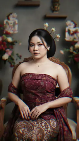 Ubahlah foto ini menjadi foto wanita muda di studio khas adat jawa yang modern dengan memakai kebaya kemben sedada merah maroon motif batik, selendang dan jarik senada mengikuti kebayanya, rambut disanggul dengan rambut samping depan kanan kiri terurai, memakai 3 tusuk konde di sanggulnya, memakai sedikit perhiasan gold, dan kuku panjang warna merah maroon, pose elegan, suasana misterius namun classy, memakai make up dan jangan ubah wajahnya #gemini #Al #prompt #jawa #trendingtiktok 