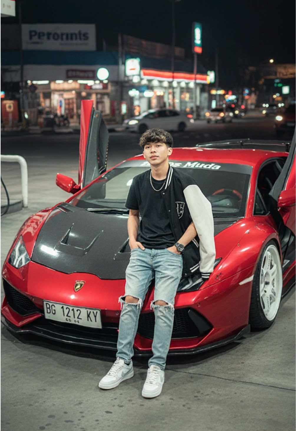 Mau foto dgn mobil impian?ai solusinya🤣 •Cari gemini ai •Upload foto yang di inginkan •Salin Promtp: Edit foto ini tanpa merubah wajah dan rambut asli foto tersebut.Bersandar di depan mobil dengan gaya kamera menyamping, mengenakan jeans robek memengang jaket vercity di pundak dengan mengenakan kaos hitam, jam tangan roxel, dan sepatu nike putih abu abu, bersandar pada bumber depan mobil honda lamborghini merah candy pintu depan terbuka yang dimodifikasi dengan pelek balap TE37 warna putih ring 16,Lampu alis merah,Cap depan carbon,full body kit suspensi rendah, setir kanan,tulisan di kaca depan atas 