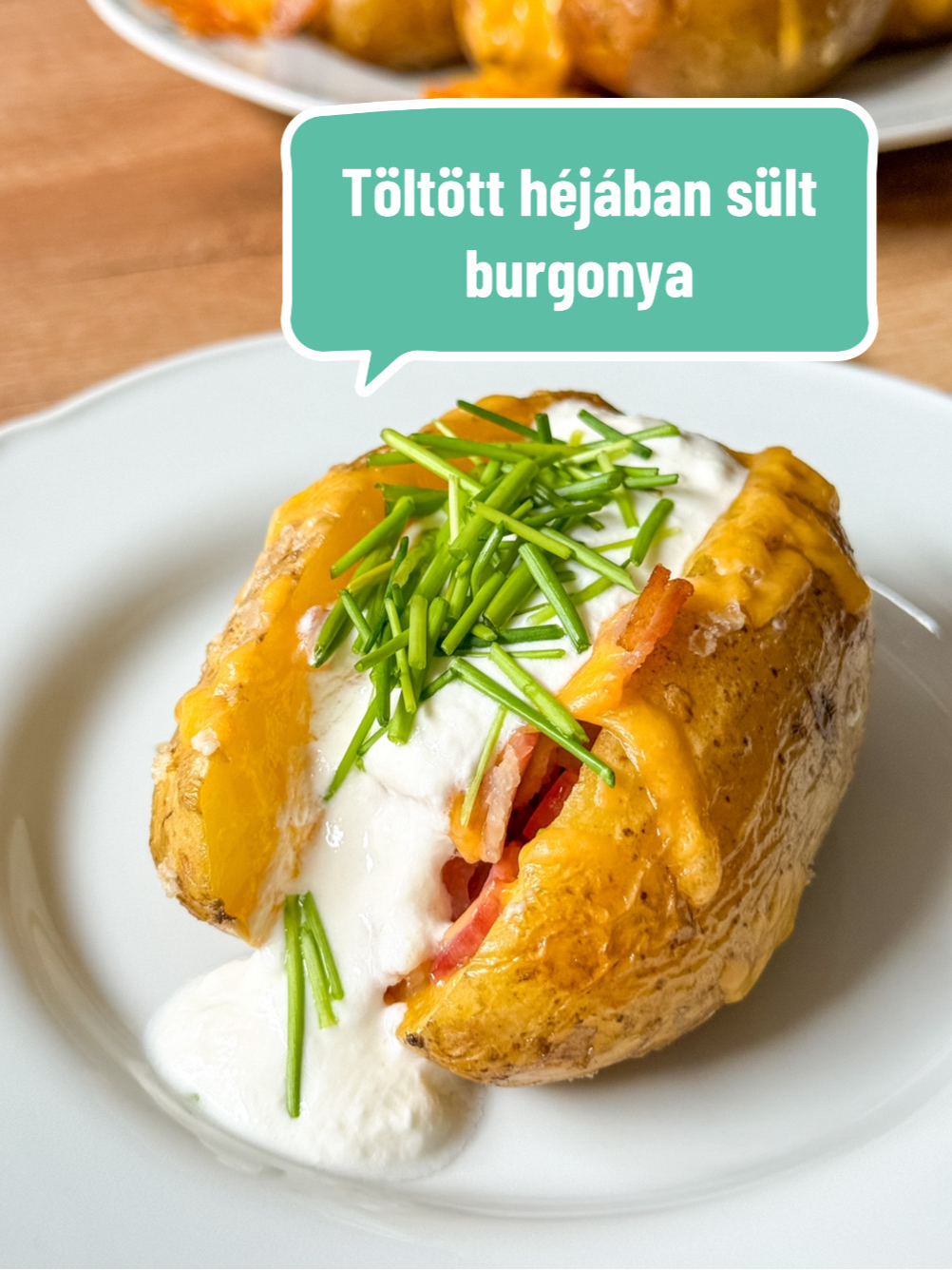 Töltött héjában sült krumpli: avagy Jacket potato Hozzávalók: 6 db burgonya 1 fej fokhagyma 2 szál rozmaring 100 g cheddar 1 csokor snidling 200 g bacon 50 g vaj 5 ek. olívaolaj só bors 1 tk. kakukkfű 175 g tejföl Elkészítés: A burgonyát zöldség tisztítóval dörzsöljük át, szurkáljuk be villával, fűszerezzük nagyszemű sóval, locsoljuk meg olívaolajjal és süssük 160 fokon 30-35 perc alatt puhára. A fej fokhagyma tetejét vágjuk le, majd csomagoljuk be alufóliába sózzuk, locsoljuk meg olívaolajjal és helyezzünk mellé két szál rozmaringot. Süssük a krumplival együtt. A bacont szeleteljük kockákra, majd serpenyőben süssük ropogósra. Egy tálban keverjük ki a vajkrémet. Ehhez dolgozzuk össze a puha vajat, kakukkfűvel, a fokhagyma sült belsejével. Ha megsült a burgonya, vegyük ki a sütőből, vágjuk félbe és villával nyomjuk össze kissé a belsejét. Kenjük rá a fűszervajat, dobjuk rá a sült bacont, végül szórjuk meg reszelt cheddar sajttal és süssük amíg a sajt aranybarna nem lesz. (körülbelül 10 perc) Amikor kivettük a sütőből, kanalazzunk tejfölt a tetejére, ezután szórjuk meg apró darabokra vágott snidlinggel. Előkészítési idő: 1 óra Elkészítési idő: 10 perc Adag: 6 db #fyp #sobors #nekedbelegyen #töltötthéjábansültkrumpli #jackedpotato #töltöttsültkrumpli