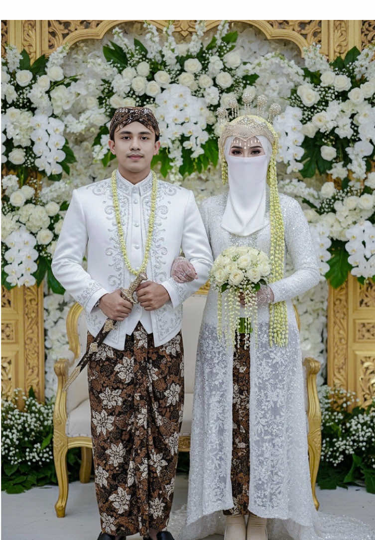 Akhirnya bisa pakai siger sunda juga 🤭🥰 Prompt : Edit 2 foto ini menjadi pasangan pengantin memakai adat sunda dengan latar belakang pelaminan di penuhi bunga. wanita berdiri di samping pria dengan mengenakan outfit gamis payet mewah syar'i panjang dan menggunakan sepatu putih dan kaos kaki, jilbab putih menutup dada dan cadar mewah manik-manik putih BUKAN masker. Anggle dari depan. Gaya elegan dan edgy dengan nuansa misterius. dua tangan memegang buket bunga putih. Ia menggunakan siger sunda dan ronce melati panjang. Pria berdiri di samping wanita mengenakan beskap putih berhias kain batik dan kalung melati, satu tangan menggandeng tangan wanita dan satu tangannya lagi memegang keris dan memakai blangko jawa, gaya senyum tipis. Nuansa foto formal dan elegan, pencahayaan studio profesional, komposisi potret pernikahan klasik. tanpa merubah wajah kualitas HD #sigersunda #sigersundahijab #adatjawa #adatsunda #pengantinjawa #pengantinsundasiger #geminiai #gemini #couple #couplegoals #pasanganromantis #trending #trend #masukberandafyp #masukberanda #foryou #foryoupage #pasutri #fypviralシ #fypシ #fypage #fyppp #fyppppppppppppppppppppppp 