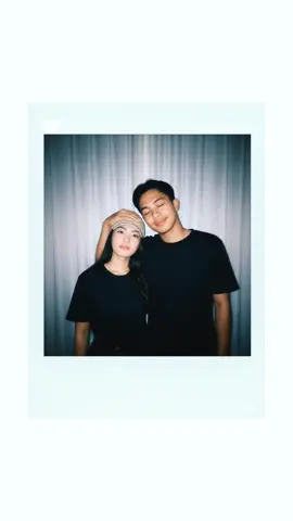 Gemini Ai prompt: Create an image captured with a polaroid camera. the photo should look like a casual snapshot with both wearing black shirt, with no clear subject or staged props. apply a slight blur effect and ensure consistent lighting as if illuminated by a camera flash in a dark room, diffused across the entire image. do not alter any faces. Don't any change of their faces. replace the background behind the two people with whote curtains. the tall man should be gently touching the short woman head. @markrainierbisa67  #geminiai #edit #fypppppppppppppp #makeitviral #fyp 