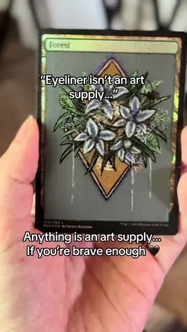 Did I used Stilla liquid eyeliner to get the chromatic effect? Yes. Am I going to to it again? Also yes. 🖤 I now have two for me and two for my art looool. 😹😹 I’m so happy I recovered on this card. I had completely destroyed it ON LIVE (ofc) when I tried a new varnish and so I had to go back and basically rework the entire thing. It will never be played because I was learning how to use the glow pigments and they got thick but it will forever be displayed with my very first one in the hands of one of the most important humans in my life, @Megs 🖤🖤 This is alssoooo why yall can’t tell me “oh I don’t have xyz so I cannnnttt” …Nah homie in this my possum kingdom and every supply is an art supply if you’re brave enough! So grab a card, grab a sharpie, eyeliner, makeup brush, highlighter and send it if you really want to start. Love y’all lol  🖤😹 Unlock Your Creativity with Fun Art Projects #funart, #creativeprojects, #diyart, #drawingchallenge, #magicthegathering 