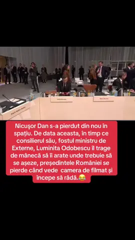 Nicuşor Dan s-a pierdut din nou în spațiu. De data aceasta, în timp ce consilierul său, fostul ministru de Externe, Luminita Odobescu îl trage de mânecă să îi arate unde trebuie să se aşeze, președintele României se pierde când vede camera de filmat și începe să râdă.