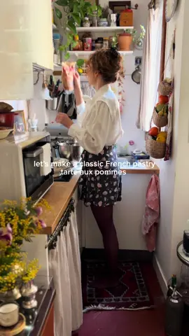 Wait till the end for a guest surprise!🐶 Recipe below! Is there anything truly better than smelling an apple dessert baking in the oven? This is my go to comfort dessert, simple with few staple ingredients to let the best of French ingredients shine through. All tools used as well as similar vintage bowls, plates, and my outfits are linked in my linktree! (If you have any questions about where anything is from in my videos, it's more than likely linked somewhere in my linktree Dough (my mold is 24cm/9inches) 130 grams of flour 65 grams of butter, cold and cut in small cubes  Pinch of salt  1 tbsp of sugar 50 grams of egg (about 1) Grease your mold. In a bowl, add all the ingredients except the egg, then rub together till sandy texture. Then add the egg and mix till comes together in a ball. Then use the palm of the hands to rub though dough once to fully incorporate ingredients. Roll between 2 sheets of parchment paper with flour. Place into mold, making sure to push the dough down the side of the mold, so it doesn't shrink when baking. Then prick with a fork.  Place in fridge or freezer for at least 30 minutes. Bake in a preheated oven at 180C till very lightly golden browned (feel free to use pie weights if you’d like when baking). Apple compote 2 apples - Granny Smith or golden delicious 1 Tbsp of butter 2 tbsp of sugar Just a splash of lemon juice Pinch of salt Optional - splash of rum, pinch of nutmeg &/or cinnamon, and a tsp or so of vanilla extract Dice the apples, then add to pan with rest of ingredients. Cook on medium heat for about 10 minutes, till apples are softened and reduced to a thick compote. Let cool then add to base of cooked tart. Assembly Peel and core 3-4 green apples, cut in half, then cut in 2mm slices. Add some apple offcuts to tart, then add sliced apples in one row, then add the offcuts to the middle to build up the next row (this keeps the apples from falling in the middle when baking as the apples reduce quite a lot when baking). Add the second row and then the top. Brush with melted butter and sprinkle with raw sugar. Then bake in a preheated oven at 180F for about 25-30 minutes (time depends on your oven) till golden browned and apples are soft. Once cooled slightly and de-molded, brush with warmed apricot jam to keep tart shiny.  Et voila, bon appetite! #paris #baking #kitchen #chef #Recipe 