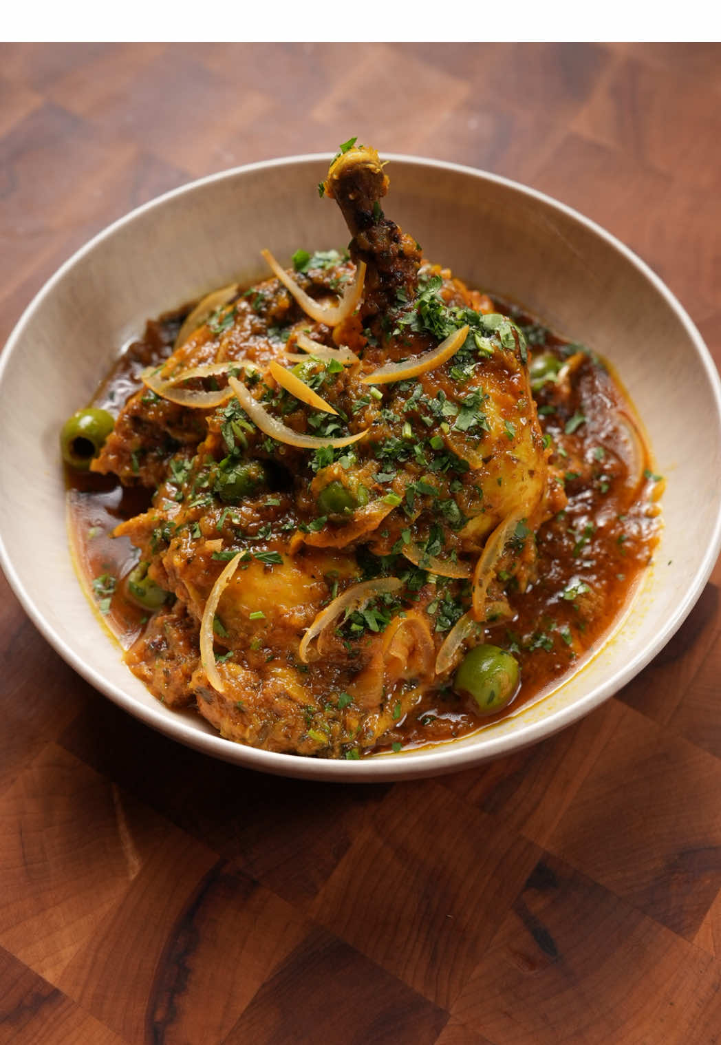 Chicken tagine with preserved lemons and olives. Full recipe is up on my website–link in bio.  As soon as the weather starts to cool down, all I want is something slow-cooked, warm, and hearty. Chicken tagine checks all those boxes.  This Moroccan classic is built on layers of flavor: floral saffron, citrusy preserved lemon, and warming spices that hit your soul. The chicken slowly releases its juices, and the onion melts in there, creating a sauce that’s rich and full of depth. It’s comforting and hearty yet vibrant and balanced from all that lemon. Eat this with good crusty bread to soak up every drop of the sauce. The best part is that it comes together effortlessly. Marinate chicken, throw it on top of some grated onion in a tagine (or pot) and let it cook slowly. No hands-on cooking needed, so it’s the perfect set and forget dish. Also great for hosting since you can make so much of it at once for not much more effort. 