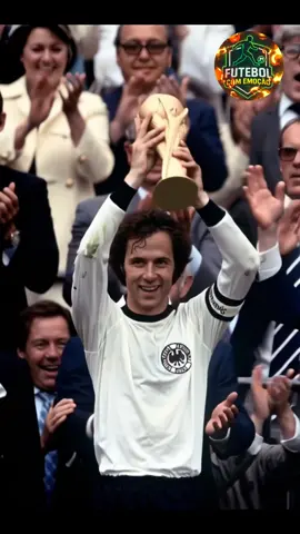 O Capitão da Glória: Beckenbauer e o Triunfo de 1974 A imagem eterniza um dos momentos mais marcantes da história do futebol: Franz Beckenbauer, o lendário capitão da Alemanha Ocidental, erguendo a taça da Copa do Mundo de 1974. Um símbolo de liderança, elegância e genialidade dentro de campo, Beckenbauer representava a perfeição tática e o espírito de uma geração vitoriosa. Diante de uma multidão e do respeito mundial, ele consagrou sua carreira e escreveu seu nome para sempre entre os maiores de todos os tempos. #Beckenbauer #Copa1974 #AlemanhaCampeã #LendasDoFutebol #HistóriaDoFutebol