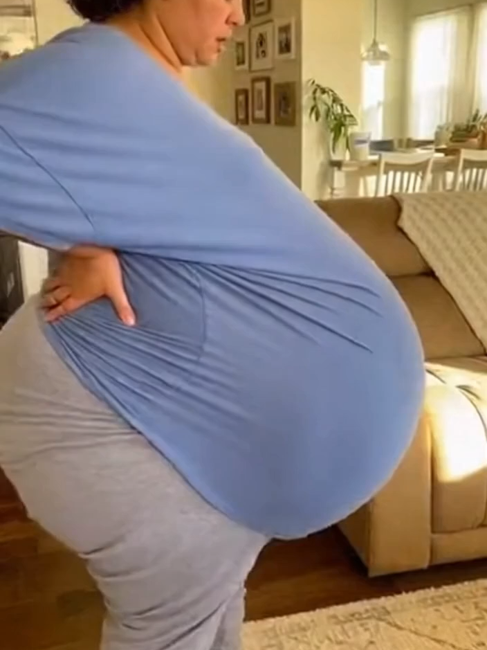 Life at 9 Months: A Mom Expecting Ten Babies Moves Through Her Day Experience a quiet, intimate moment from inside a cozy home. This amateur-style video captures a woman in the final month of a rare pregnancy with ten babies. Her belly is extremely large, and every movement requires effort as she slowly makes her way across the room. With her legs slightly bent from the weight and her breathing heavy and careful, she supports her back and belly while moving through her daily routine. The scene is raw, warm, and deeply human—showing the strength, fatigue, and determination of a mom carrying an extraordinary pregnancy. No dialogue, no acting—just a simple, peaceful, real-life moment. #PregnancyJourney, #ExpectingMom, #RarePregnancy, #Motherhood, #RealLifeMoments, #HomeVideo, #NineMonths, #HumanStrength, #FamilyLife, #DocumentaryStyle, #Pregnancy, #pregnant, #baby,