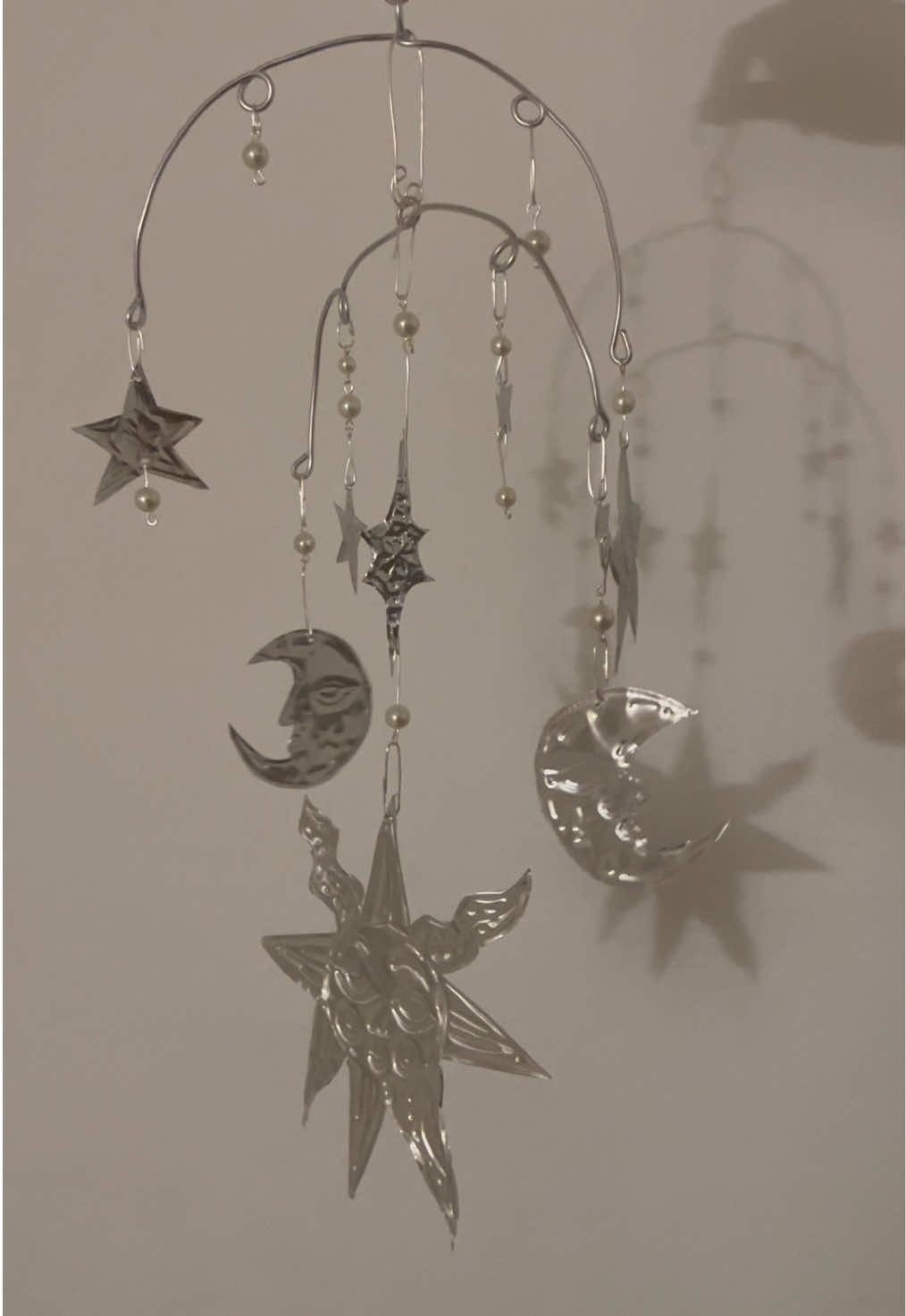 My latest creation, a handmade mobile made from embossing foil, wire, and pearl beads! I had a great time making each of the embossings and figuring out how to assemble them together. I think it’s so lovely the way the shadows of the sun and stars are cast upon the wall, definitely a worthwile art project :)  #foryoupage #embossing #handmadeart #sunmoon #foilart 