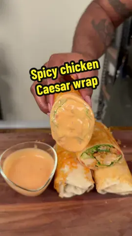 Spicy chicken Caesar wrap recipe ⬇️ ~48g Protein | ~860 Calories Ingredients (all from Kroger): • 6 large flour tortilla • 12 frozen chicken tenders (air fried) • 3/4 cup Caesar dressing • 3/4 cup  hot sauce • About 1 lb of romaine lettuce • 4 Diced tomatoes • Shredded parmesan (inside) • parmesan for the cheese “blanket” #spicychicken #spicychickencaeserwrap #wraps #highprotein #protein 