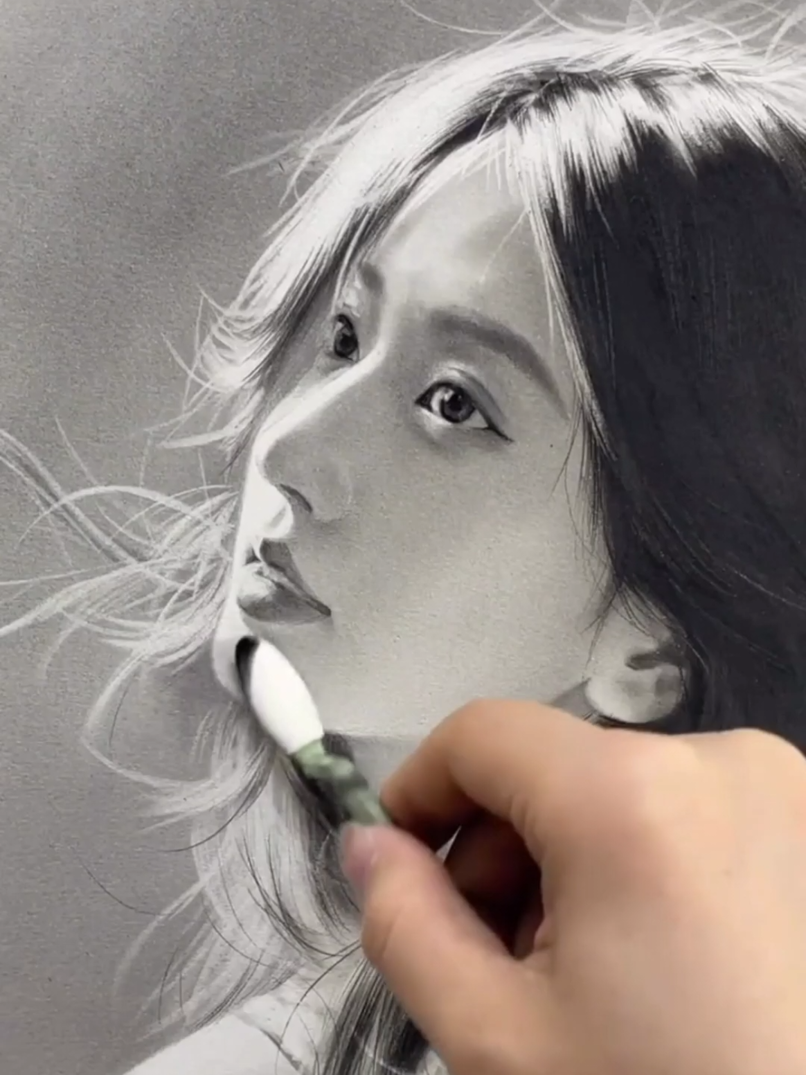 She begins with a cloud of graphite dust, then uses an eraser to pull the portrait out of the shadows, carving the proportions & silhouette before adding the line work. From there, charcoal & colored pencil bring the details to life, turning a soft haze of graphite into a strikingly realistic portrait. Artist artzy_y01 (Instagram) #realisticart #hyperrealistic #portraitart #pencil