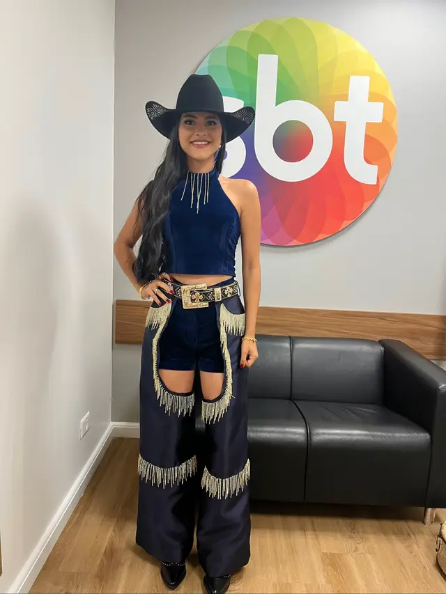 Hoje não é só mais uma gravação... é um marco na minha vida.✨ Eu estou pronta. Pronta de corpo, alma e coração. Esse look não nasceu por acaso... ele foi gerado do zero, pensado em cada detalhe, carregado de propósito. O azul em veludo não é só uma escolha estética — ele representa o manto sagrado da minha rainha, Nossa Senhora Aparecida a mãe do meu Senhor, aquela que me sustenta, me guia e me trouxe até aqui. Cada brilho que você vê carrega uma lágrima que eu já derramei, cada detalhe tem um pedaço da minha história, da minha fé e da minha luta. Eu misturei o country, que é a minha raiz... com o brilho, que representa o sonho... e com a fé, que é o que nunca me deixou desistir. Hoje eu não estou entrando só em um palco... Eu estou entrando vivendo uma promessa. Se eu cheguei até aqui, não foi só por mim. Foi por Deus... e pelas mãos da minha mãe Nossa Senhora Aparecida.✨💙