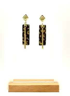 Add a fierce pop of pattern to any outfit with these handmade leopard-print earrings. Each lightweight rectangle is sculpted from durable polymer clay, hand-painted in a classic black-and-gold cheetah motif, and finished with a sleek vertical bar for modern sway. The studs and bars are a bright, tarnish-resistant shine that flatters every skin tone. Because every pair is handcrafted, the spot pattern and brush-stroke texture are uniquely yours—no two sets are ever identical. Comfortable enough for all-day wear yet bold enough for a night out, they’re the perfect accessory for anyone who loves eye-catching, fashion-forward design. Features you’ll love Lightweight feel, big impact – polymer clay keeps them feather-light, gold bars add luxe movement. Hand-painted leopard / cheetah spots – each rectangle block is individually detailed. Gold-plated studs & bars – stylish, hypo-allergenic hooks. Thoughtful packaging – mounted on a branded display card and tucked in a sturdy white gift box—ready to give or keep. Gifting & styling ideas Wear them with a plain tee and jeans for an instant style upgrade, pair with a little black dress for cocktail chic, or wrap them up for your wild-at-heart bestie. They’re a hit for birthdays, bridesmaid boxes, or “just-because” surprises. Care tips Wipe gently with a soft, dry cloth; store in the gift box when not in use. Avoid water, perfumes, and hair sprays to keep the gold finish gleaming.