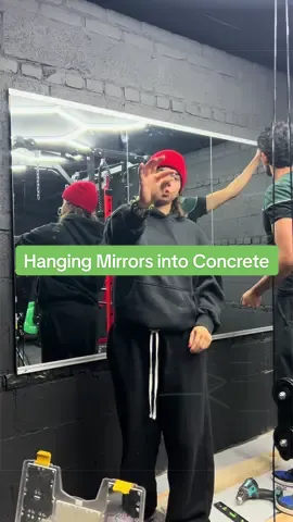 Hanging mirrors into our concrete walls for our garage gym!! #hangingmirror #garagegym #mirrors #homerenovation #concrete 