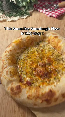 Same Day Sourdough Pizza  (No Knead!) Ingredients: 	•	260g flour (2 cups) 	•	210g water (¾ cup + 2 tbsp) 	•	80g active starter (⅓ cup) 	•	2 tbsp olive oil 	•	1 tsp salt ⸻ Instructions: 	1.	In a bowl mix water + starter + flour. Cover and rest 35 min. 	2.	Add salt + olive oil and do a coil fold until the salt is fully incorporated. Cover and rest 35 min. 	3.	Do a second coil fold (total 2 coil folds), but this time keep folding multiple times in the same session until the dough tightens and you can’t fold it easily anymore. 	4.	Cover and let it rest for about 3 hours or until doubled (depends on room temp). 	5.	Transfer dough onto well-floured parchment paper and gently shape into a circle without deflating. 	6.	Dust the top very well with flour, cover 20 min, then gently stretch from the sides while keeping the air inside and lightly press only the center. Add tomato sauce, cheese, then finish with thyme + olive oil. 	7.	Bake at preheated oven (tray inside) at maximum temperature for at least 30 minutes. Slide pizza in using a peel or cardboard, bake 10 minutes exactly, then remove immediately so it doesn’t burn. #sourdough #sourdoughpizza #sourdoughbread #sourdoughtok #sourdoughforbeginners 