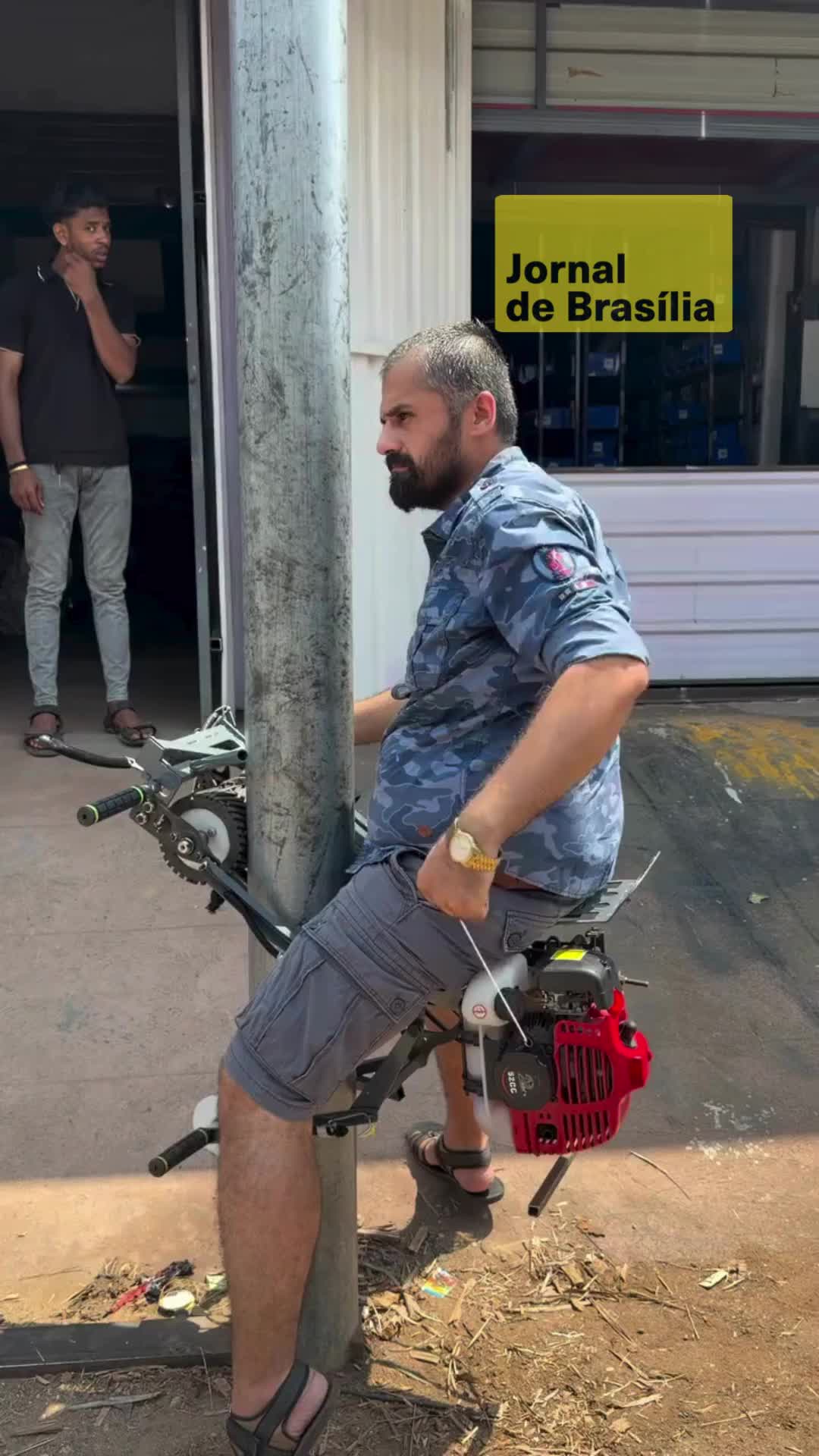🛠️ Um equipamento agrícola desenvolvido para facilitar a escalada em árvores de areca foi apresentado em uma demonstração realizada dentro de uma loja de ferragens. Como não há árvores no local, a máquina foi testada em um poste redondo, simulando as condições de uso no campo. 🚜 O dispositivo, movido a gasolina e equipado com assento de apoio, permite a subida vertical com menor esforço físico, sendo voltado para atividades como a colheita da noz de areca. Durante a gravação, um cliente testou o equipamento enquanto recebia as orientações sobre o funcionamento. 📹: @bviral #jornaldebrasilia