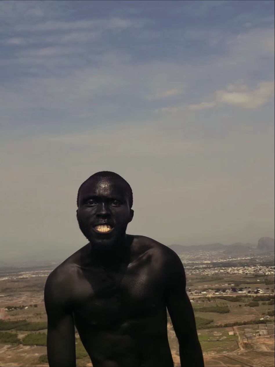 Standing tall over Karsana like a black king 🖤😤 Full blackout mode, energy roaring louder than the whole city below. From the ground to the hills, I own every view. Who’s feeling this power? Drop a 🔥! #StreetPerformer #BodyArt #Karsana #AbujaRaw #NaijaEnergy 