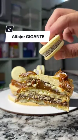 Alfajor GIGANTE de maicena! 🔥 Receta para un alfajor triple de 16cm y 12 alfajorcitos de 4cm aproximadamente… 👇🏻 -125gr de manteca pomada -60gr de azúcar -3 yemas o un huevo!  -1 cucharada de esencia de vainilla @radhacolors  -90gr de harina leudante -160gr de almidón de maíz también conocido como maicena Hornear las tapas a 180° las tapas minis salieron a los 8 minutos, las más grandes tardaron un poco más en dorarse! 🔥 Rellene con el mejor dulce de leche repostero, súper firme de @fincalacaramela.srl 🐮 Para decorar use la boquilla 22 de @cooperreposteria 💜 agregue más coco rallado y finalice con los mini alfajorcitos