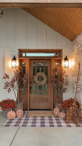 Fall porch decor! 🍂🎃 I love how this turned out!🥹🤎 I want our porch to feel warm and welcoming. Like cozy classic fall.🤎🍂 The plaid rug feels so warm and cozy. It sets the perfect tone for fall. I added some tall autumn trees in a wicker basket. I wrapped fairy lights around my trees to give them a cozy glow in the evenings!  I also added some orange artificial mums to give it a classy fall feel! Then I added some terracotta pumpkins and a light up broom. The broom is probably one of my favorite pieces of fall decor! It’s so pretty!🍂 #fall #falldecor #falldecorating #mums #fallvibes 