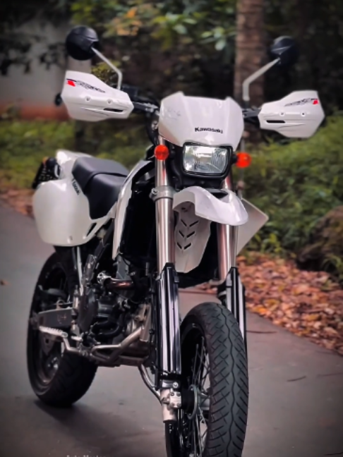 ලංකාවේ Traffic එකට ගැළපෙනම ජපන් Supermoto යන්ත්‍රය: Kawasaki D-Tracker 250 සම්පූර්ණ තාක්ෂණික විවරණය ⚙️ Supermoto සංකල්පයේ ජපන් සලකුණ: Kawasaki D-Tracker 250 තාක්ෂණික විවරණය ⚙️ Off-road යතුරුපැදියක (Dirt Bike) චැසියකට, මහපාරේ ධාවනය කළ හැකි ටයර් සහ ඇලෝයි වීල් (Alloy wheels) සවි කිරීමෙන් නිර්මාණය වන යතුරුපැදි කාණ්ඩය 'Supermoto' ලෙස හැඳින්වේ. කවාසාකි සමාගම විසින් නිර්මාණය කළ D-Tracker 250 යනු මෙම Supermoto තාක්ෂණය උපරිමයෙන්ම පෙන්වන, නාගරික තදබදයට මෙන්ම Stunt ධාවනයට ද ඉතා ජනප්‍රිය වූ යතුරුපැදියකි. එන්ජිම සහ කාර්යසාධනය (Engine Specs) ⚙️ කිසිදු සංකීර්ණ ඉලෙක්ට්‍රොනික පද්ධතියකින් තොරව, සම්පූර්ණයෙන්ම යාන්ත්‍රික (Mechanical) පදනමක් මත මෙහි එන්ජිම ක්‍රියාත්මක වේ. ධාරිතාව: 249cc, Liquid-Cooled (ද්‍රව සිසිලන), 4-Valve, DOHC එන්ජිම. ඉන්ධන සැපයුම: Keihin CVK34 Carburetor (කාබ්යුරේටර්) පද්ධතිය. උපරිම බලය: අශ්වබල 29 ක් (29 HP) @ 9,000 RPM. උපරිම ව්‍යවර්ථය: නිව්ටන් මීටර 25 ක් (25 Nm) @ 7,000 RPM. චැසිය, බර සහ හැසිරවීම (Chassis & Handling) 🏍️ Off-road යතුරුපැදියක බඳ භාවිතා කරන බැවින් මෙහි සම්පූර්ණ වියළි බර (Dry weight) කිලෝග්‍රෑම් 119 ක් වැනි ඉතා කුඩා අගයක් ගනී. අඟල් 17 ප්‍රමාණයේ ඇලෝයි වීල් සමගින් ඉදිරිපසට 110/70 සහ පසුපසට 130/70 ප්‍රමාණයේ ටයර් යොදා ඇත. මෙහි බර අඩුකම සහ පුළුල් හැන්ඩ්ල් බාර් (Handlebar) එක නිසා 'Counter-steering' තාක්ෂණය භාවිතා කරමින් ඉතා පහසුවෙන් සහ වේගවත්ව වංගු ගැනීමේ (Cornering) හැකියාව රියදුරාට ලැබේ. ධාවන වේගය (Speed & Acceleration) 🚀 මෙම යතුරුපැදිය නිර්මාණය කර ඇත්තේ ඉහළ උපරිම වේගයක් (Top speed) ලබා ගැනීමට නොව, ක්ෂණික ත්වරණයක් (Acceleration) ලබා ගැනීමටයි. එමනිසා මෙහි 6-Speed ගියර් පද්ධතියේ අනුපාතයන් (Gear ratios) සකස් කර ඇත්තේ තත්පර 6 කින් පමණ පැයට කිලෝමීටර 100 වේගය ලබාගැනීමටයි. මෙහි උපරිම වේගය පැයට කිලෝමීටර 140 කට සීමා වේ. වේගය පාලනයට ඉදිරිපස සඳහා මිලිමීටර 250 ක තැටි තිරිංගයක් (Disc brake) අඩංගු කර ඇත.(විශේෂ සටහන: වීඩියෝවේ දැක්වෙන්නේ සම්මත Exhaust පද්ධතිය වෙනුවට, යතුරුපැදියේ කාර්යසාධනය සහ නාදය වැඩි කිරීම සඳහා යෙදූ FMF Aftermarket Exhaust එකකි). යතුරුපැදි ඉංජිනේරු කලාවේ මෙවැනි සත්‍ය සහ නිවැරදි තාක්ෂණික තොරතුරු පමණක් දැනගන්න Auto Master පිටුව අනිවාර්යයෙන්ම Follow කරන්න! ​#KawasakiDTracker250#SupermotoSriLanka#DTracker250#SinhalaBikeReview#BikeLoversSL