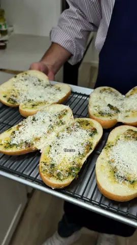 My go-to garlic bread. Simple to make, hard to resist. • 1/2 cup unsalted butter • 1 whole head of roasted garlic • 1 tablespoon of fresh chopped parsley • A pinch of salt • A pinch of red pepper • 4 hero rolls Preheat the oven to 400°F. Cut the top off the head of garlic to expose the cloves. Drizzle with olive oil and season with salt. Wrap tightly in foil and roast for 40 minutes, or until the cloves are soft and golden. Squeeze the roasted garlic into a small frying pan. Add the butter, salt, and red pepper. Cook over low heat until the butter is melted and everything is well combined, smashing the garlic into smaller pieces as you stir. Add the chopped fresh parsley and mix to combine. Spread the garlic butter generously over the bread and top with plenty of grated Parmesan. Bake at 375°F for about 12 minutes, or until the bread is golden brown and crisp.