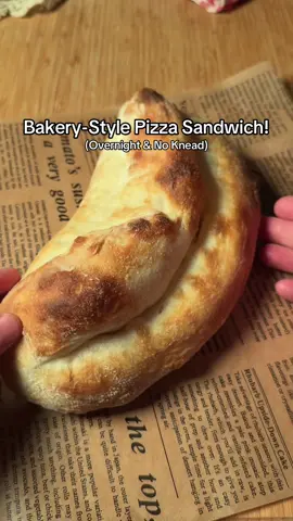 No-Knead Pizza Sandwich Ingredients: * 150g flour (1¼ cups) * 105g water (about 7 tbsp) * ½ tsp yeast * 1 tsp sugar * 1 tsp salt * 1 tbsp olive oil Instructions: 1. In a bowl, mix yeast, sugar, and water. Add flour, salt, and oil, then coil fold several times until everything is combined. 2. Cover and let rest for 20 minutes, then coil fold again. Cover and refrigerate overnight. 3. The next day, remove the dough from the fridge and let it sit at room temperature for 30 minutes. 4. Generously flour parchment paper, place your dough on it, and gently shape it into a ball. 5. Flip the dough, cover with a bowl, and let rest for 20 minutes. 6. Gently flatten the center, keeping the edges thick and the middle thin. 7. Generously drizzle olive oil over the center and edges, then fold the dough in half. 8. Preheat your oven to its highest temperature, then bake for about 10 minutes. 9. Fill with your favorite sandwich fillings and enjoy! #pizza #homemadepizza #baking #bakingtok #breadtok  